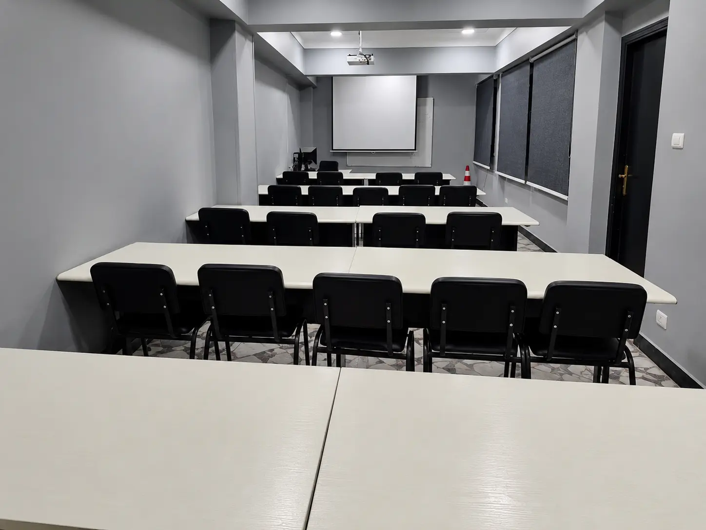 Classroom-layout training hall at Tarradco Academy with projector screen and desks ready for a new batch